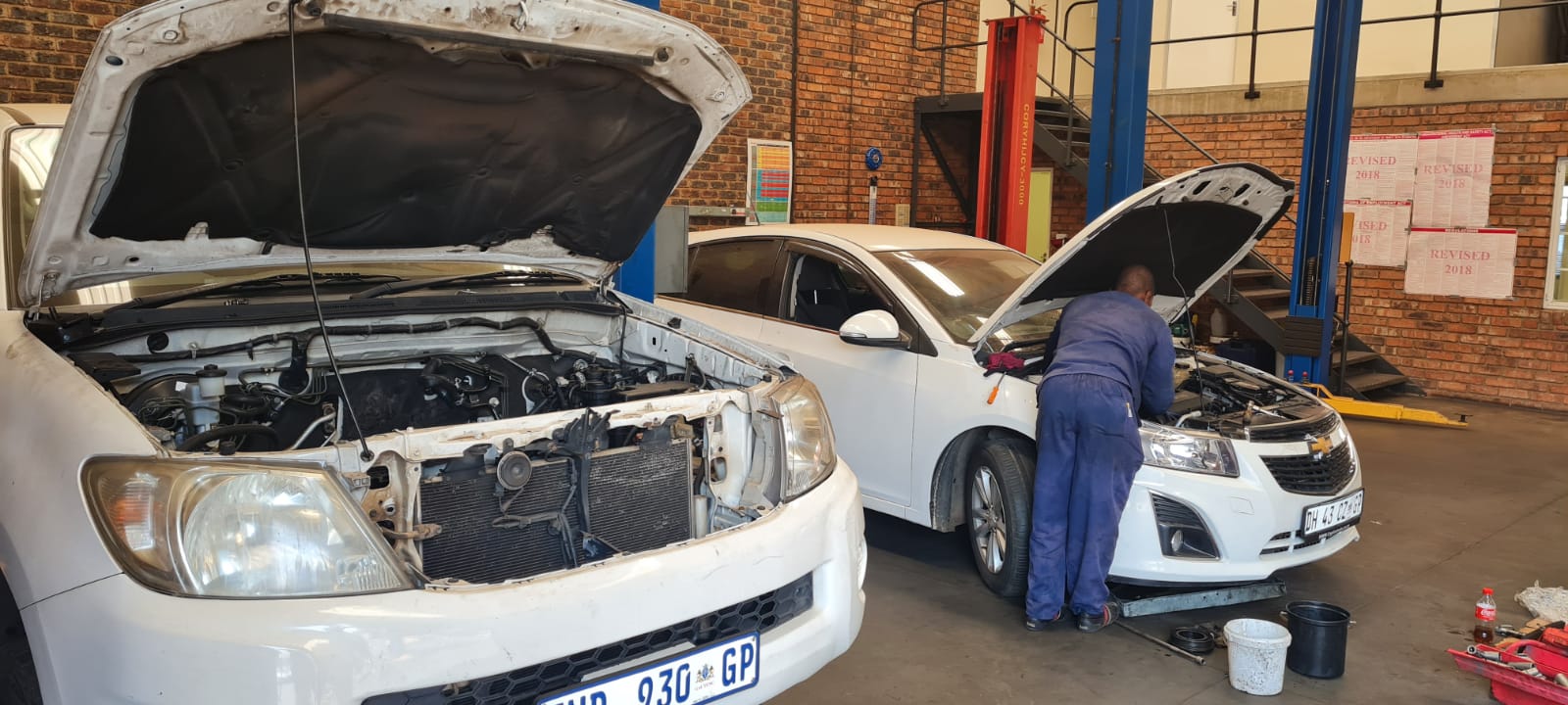 mechanic fixing two cars